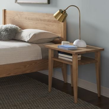 Modern minimalist bedroom featuring a handcrafted solid wood bed in natural ash with a matching nightstand and dresser