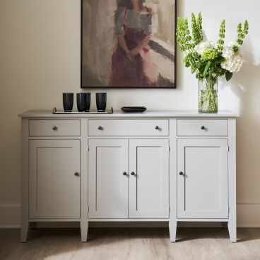 Contemporary buffet featuring a clean-lined design with ample storage, complemented by a vase of hydrangeas and green stems.