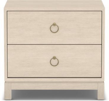 A handcrafted solid wood nightstand in a light finish, featuring two spacious drawers with elegant brass ring handles for stylish bedroom storage.