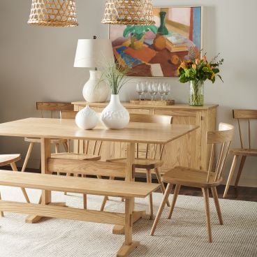 Trestle dining table paired with matching Appalachia wood chairs and bench, styled in a cozy dining room with warm accents and natural light.