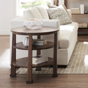 Round wooden side table with three shelves, perfectly complementing a modern or traditional living room.