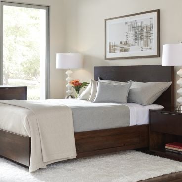 Elegant bedroom featuring a dark wood platform bed with built-in storage, complemented by matching nightstands and a dresser, creating a warm and sophisticated retreat.
