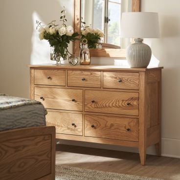 Solid wood Vineyard 54&quot; Dresser with a beautifully crafted mirror, adorned with a vase of roses and a table lamp.