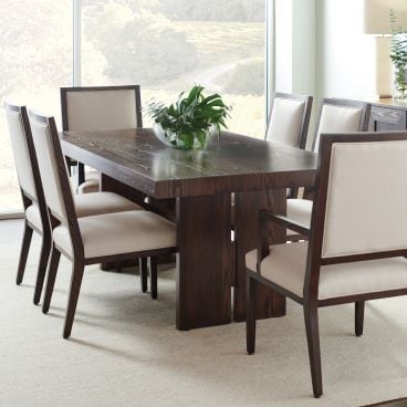 Elegant dining space with a handcrafted wooden table, neutral-toned upholstered chairs, and a sleek storage cabinet