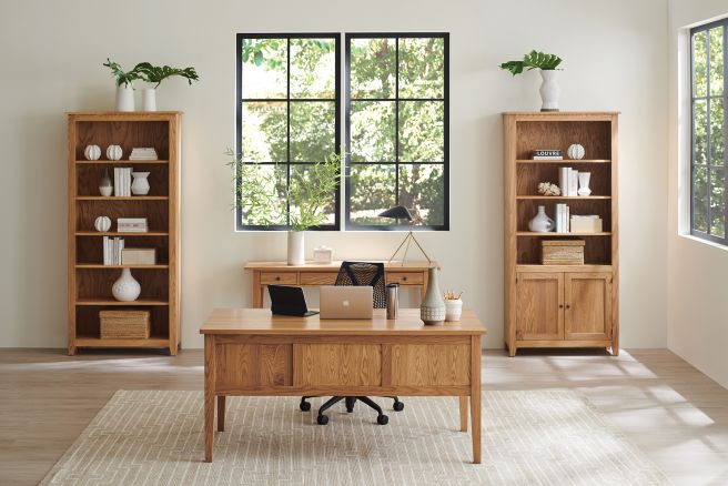 Wooden desk and matching bookshelves in a bright and modern home office setting.