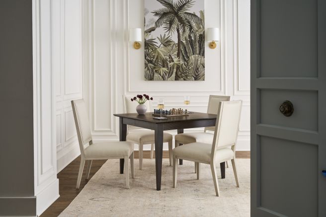 Solid wood game table and four upholstered chairs in a bright interior design setting, handcrafted from Appalachian hardwood with a chess board and drinks on top.