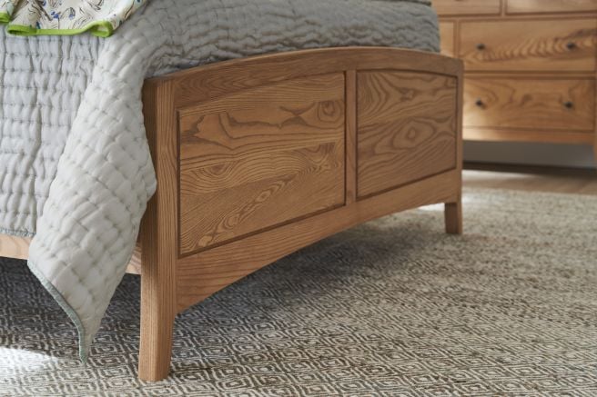 Close-up view of the footboard of a Chelsea Queen Bed showcasing the intricate wood grain of the Appalachian hardwood and elegant panel design.