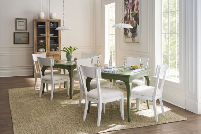 Solid wood game table with matching dining chairs in a bright room, set with tiles and drinks for a casual gathering.
