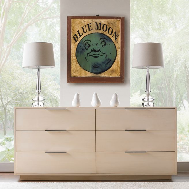 Sleek wooden dresser with six drawers, featuring recessed handles and a minimalist design, set in a bright, nature-filled room.