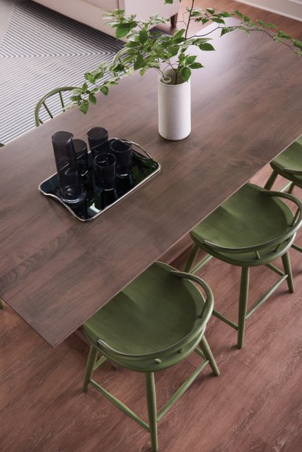 Close-up of counter height chairs with a smooth rectangular table top, showcasing modern craftsmanship and design.