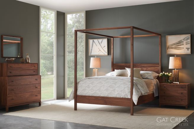 A handcrafted solid wood canopy bed with a modern frame, paired with matching real wood furniture in a serene bedroom setting.