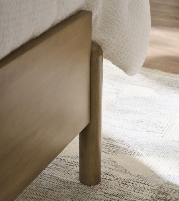 Close-up view of the Josie bed`s wooden footboard and cylindrical leg, highlighting its minimalist and sturdy craftsmanship.