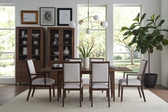 Sophisticated dining area showcasing a wooden dining table and chairs with upholstered seats, alongside wooden display cabinets filled with decor.