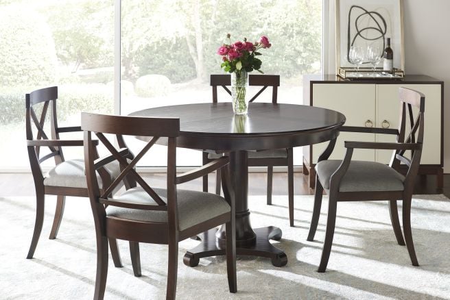 Stylish dining set featuring a round pedestal table with upholstered chairs, ideal for formal or casual gatherings.