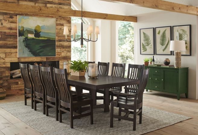 Elegant dining room featuring a handcrafted solid wood trestle table with high-backed slatted chairs in a rich dark finish.