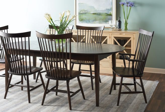 Dining room with a dark maple wood table and matching spindle-back chairs, complemented by a light-colored sideboard.
