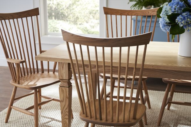 Detailed shot of a hardwood dining table paired with wooden spindle chairs, highlighting the smooth finish and elegant design.
