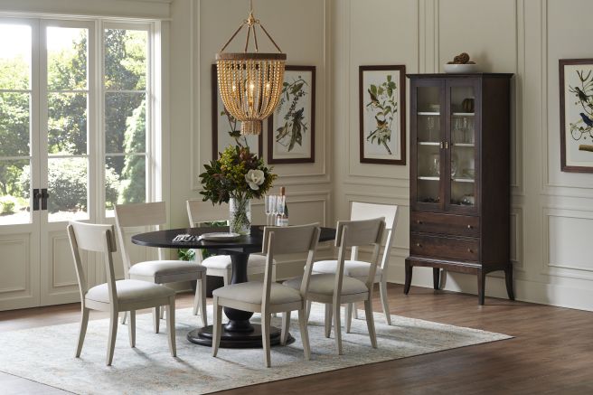Elegant glass cabinet with wooden frame, showcasing glassware and decor, complemented by lower storage drawers.