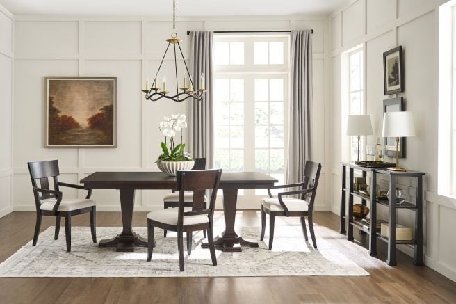 A dining room styled with a sleek wooden table, chairs, and a refined console table in a classic design.