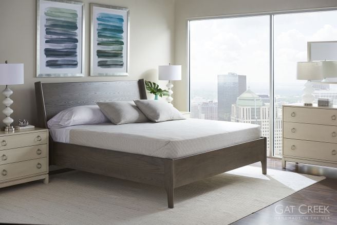 A contemporary bedroom with a natural hardwood bed frame and matching nightstands, designed to complement the airy, light-filled space.