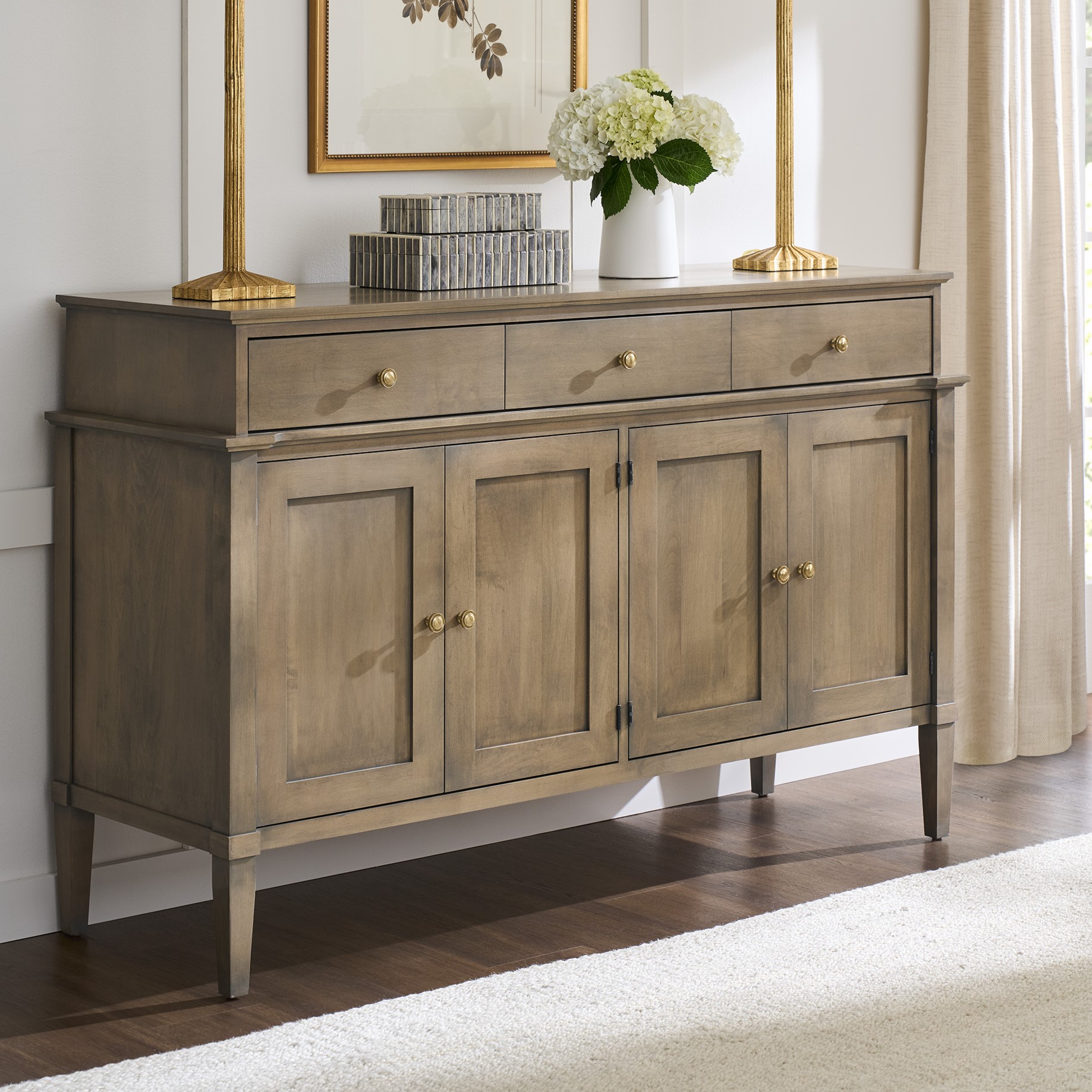 Classic solid wood buffet with ample storage, including drawers and cabinets, finished in a warm neutral tone with gold accents.