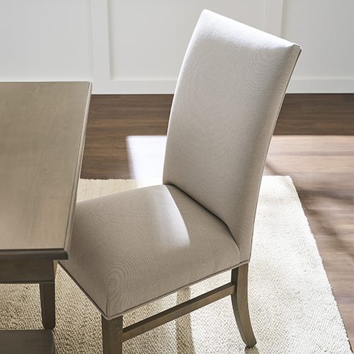 Comfortable high-back dining chair with soft upholstery and a sturdy wooden frame, complementing a classic dining setting.
